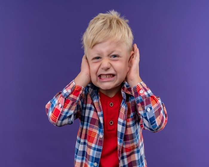 angry-little-boy-with-blonde-hair-wearing-checked-shirt-keeping-hands-ears