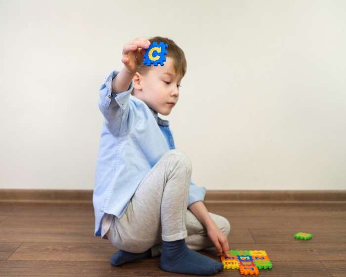 little boy playing with alphabet game