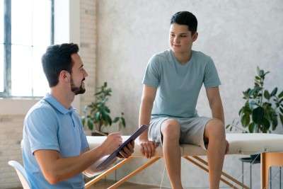 doctor helping boy physiotherapy medium shot