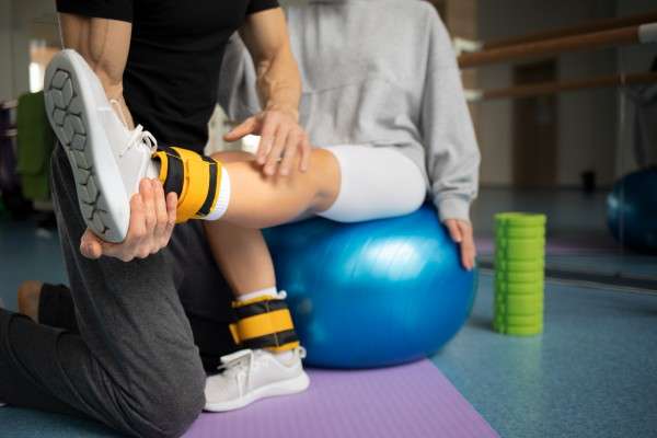 photo patient doing physical rehabilitation helped by therapists