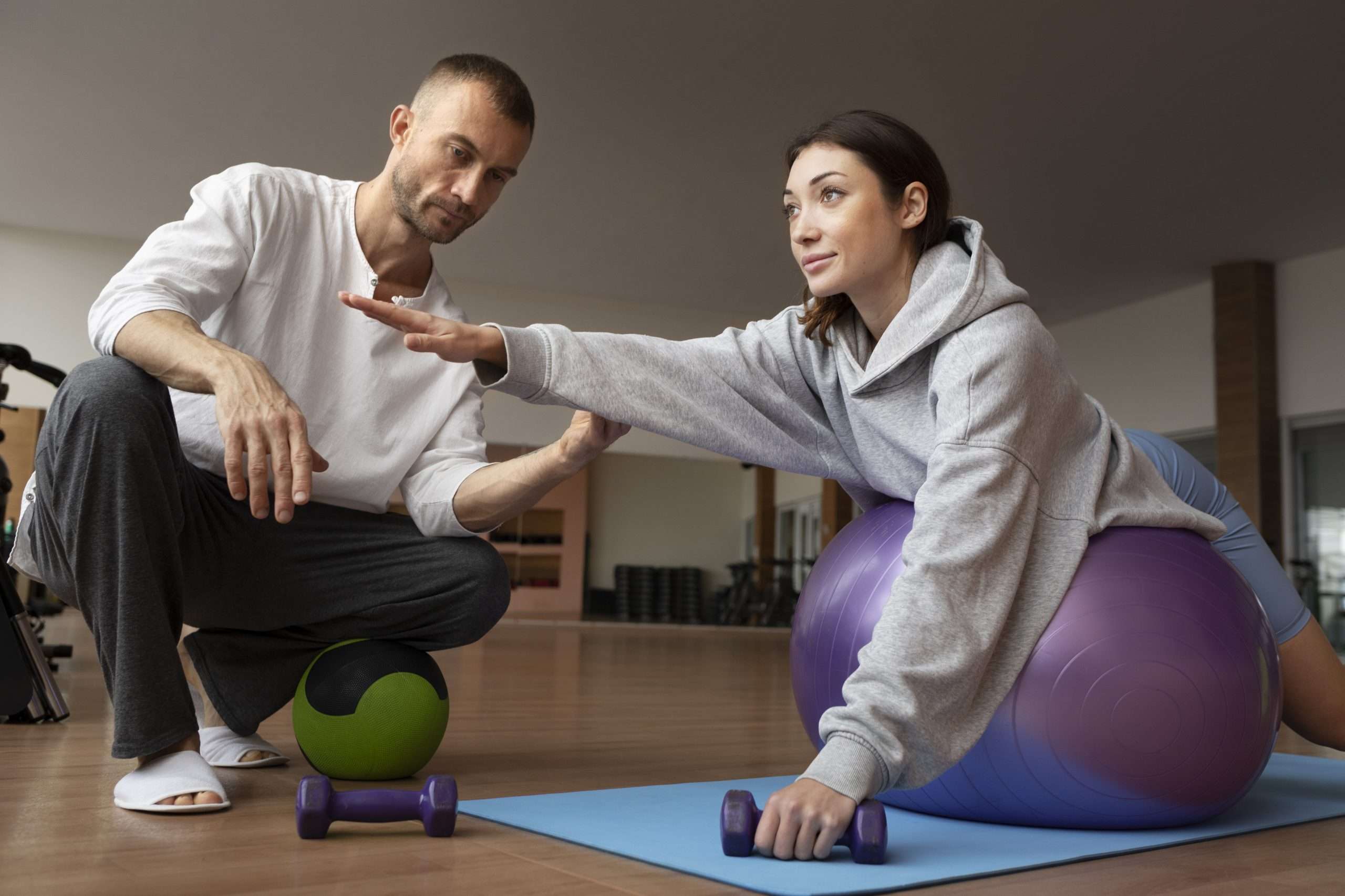 Patient doing physical rehabilitation helped by therapists